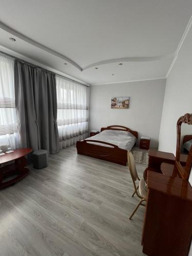 a bedroom with a bed and a desk and a desk at Оазис in Zalishchyky