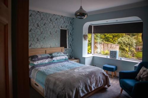a bedroom with a bed and a window and a chair at Entire Family Home By The Sea in Scarborough