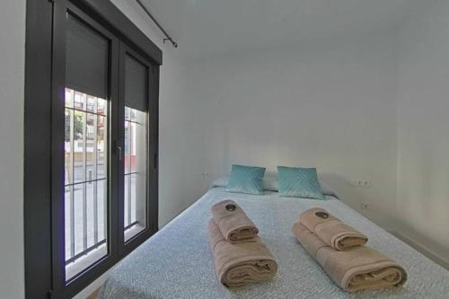 a bedroom with a bed with towels on it at Luxury apartment in sevilla center in Seville