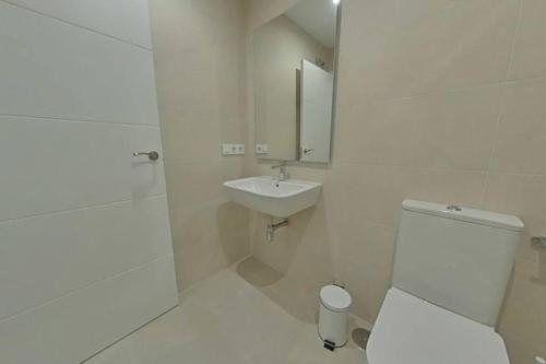 a white bathroom with a toilet and a sink at Luxury apartment in sevilla center in Seville