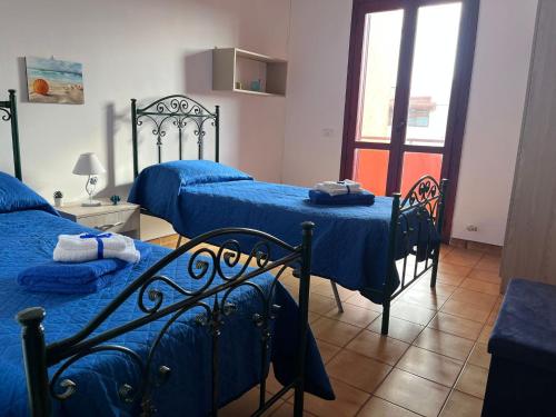 sypialnia z 2 łóżkami i niebieską pościelą w obiekcie Caravaggio Apartment w mieście Porto Cesareo