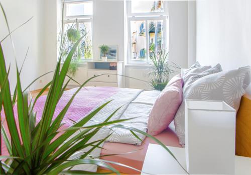 a bedroom with a bed with pillows and a plant at Bis 6 Personen - 5 Min zur Elbe, Helle Geräumige 2-Raum-Whg, Neustadt, Top Lage in Dresden
