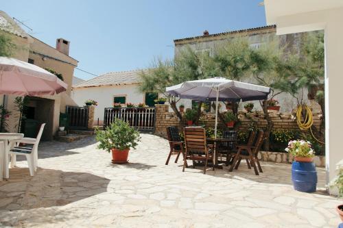 a patio with a table and chairs and an umbrella at haus toni in Ražanac