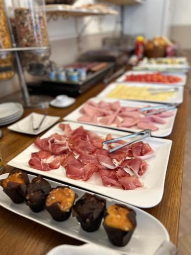 a table with several plates of meat and brownies at Haus Maria in Bruck an der Großglocknerstraße