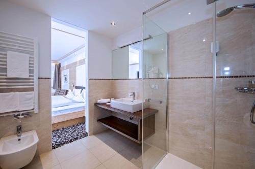 a bathroom with a sink and a glass shower at Hotel Garni Aghel in Selva di Val Gardena