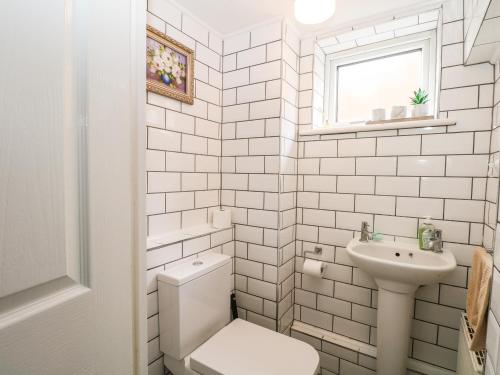 a white bathroom with a toilet and a sink at Alverstone Seaside in Gosport