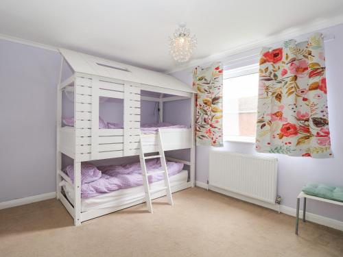 a bedroom with a white bunk bed and a window at Alverstone Seaside in Gosport