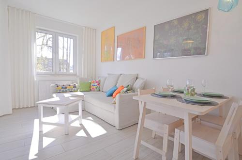 uma sala de estar com um sofá branco e uma mesa em Apartamenty Bryza - Ulanska - Parking em Świnoujście