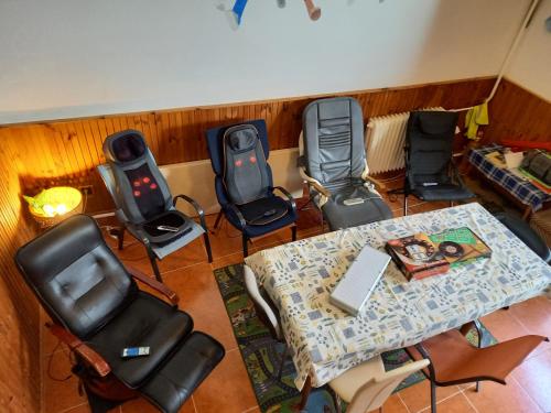 a group of chairs and a table with a laptop on it at Triniti Vendégház in Eger