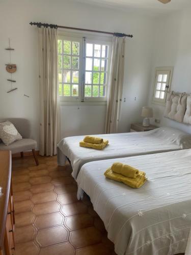 sypialnia z dwoma łóżkami z żółtymi ręcznikami na nich w obiekcie 2 Bedroom Apartment , Son Bou w Son Bou