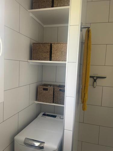 łazienka z toaletą i koszami na półkach w obiekcie 2 Bedroom Apartment , Son Bou w Son Bou