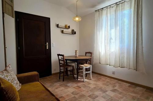 a dining room with a table and chairs and a window at L'Elementariu in Nonza
