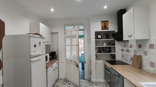 kuchnia z białymi urządzeniami i białą lodówką w obiekcie Maison des années 30 - Vic-Sur-Cère - 4 personnes w mieście Vic-sur-Cère