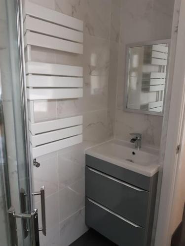 a white bathroom with a sink and a mirror at Charming Mid Terrace Cottage in Conwy