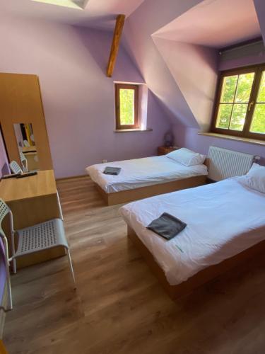 a attic room with two beds and a chair at Chata Mazurska Marek Pyśk in Mrągowo