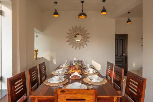 a dining room with a wooden table and chairs at StayVista at Rolling Hills with Pool, Lawn & Pet Friendly in Tota Ām