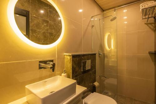 a bathroom with a sink and a toilet and a mirror at StayVista at Rolling Hills with Pool, Lawn & Pet Friendly in Tota Ām