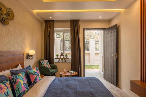 a hotel room with a bed and a chair at StayVista at Rolling Hills with Pool, Lawn & Pet Friendly in Tota Ām