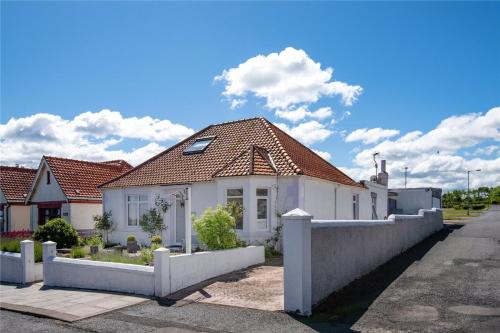 una casa blanca con una valla delante en Hillcrest Bed & Breakfast, en Eyemouth