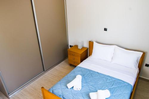 niewielka sypialnia z łóżkiem i 2 białymi ręcznikami w obiekcie Southplace63 Cozy house 500m From beach w mieście Vari