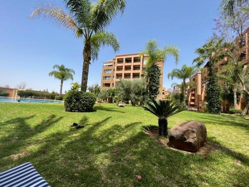 een park met palmbomen en een standbeeld in het gras bij APPARTEMENT MARRAKECH HIVERNAGE in Marrakesh