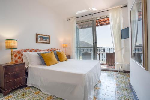 ein Schlafzimmer mit einem Bett und einem großen Fenster in der Unterkunft Villa Levante in Positano