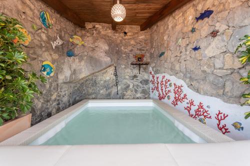 einen Pool in einem Zimmer mit einer Steinmauer in der Unterkunft Villa Levante in Positano