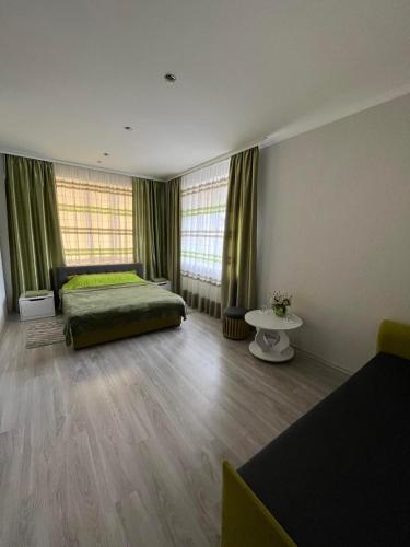 a bedroom with a bed and two windows at Оазис in Zalishchyky