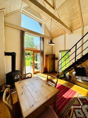 a dining room with a wooden table and a fireplace at Cisowe Wzgórze in Rowele