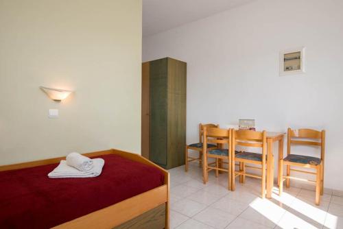 a bedroom with a bed and a table and chairs at Barbie Hotel Apartments in Ialyssos