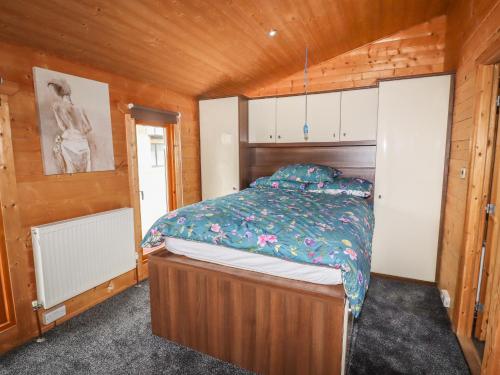 1 dormitorio con 1 cama en una habitación de madera en Tilly's Lodge, en Doncaster