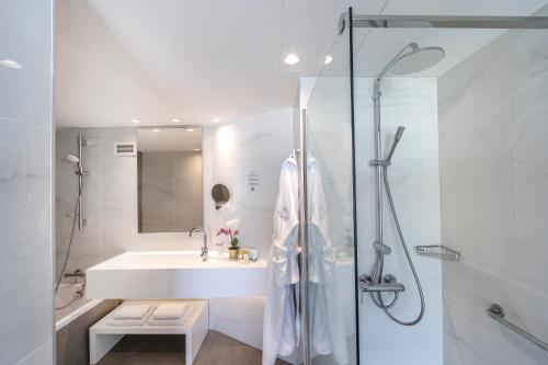 a white bathroom with a sink and a shower at Pavlo Napa Beach Hotel in Ayia Napa