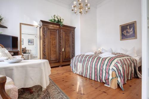 Villa Minheim - FeWo 04 في هيرينجسدورف: غرفة نوم بسرير وطاولة وثريا