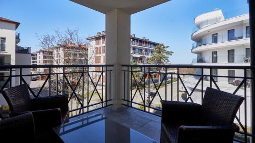 a balcony with chairs and a view of a building at Promenada I, Sun & Snow in Świnoujście