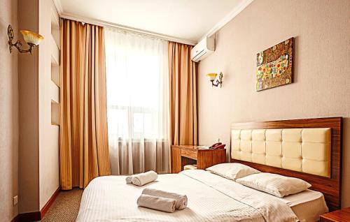 a hotel room with a bed with towels on it at KORSAR in Astana