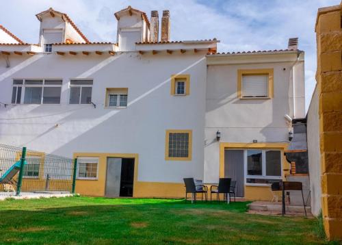 a white house with a table and chairs in the yard at Cuencaloft Casa Rural Lagunas de Arcas in Arcas