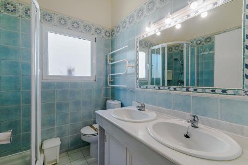 a bathroom with two sinks and a mirror and a toilet at Bahia Dorada 4 in Estepona