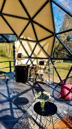 Tienda grande con mesa y sillas en Glamping dome tent BUUDA, en Salacgrīva