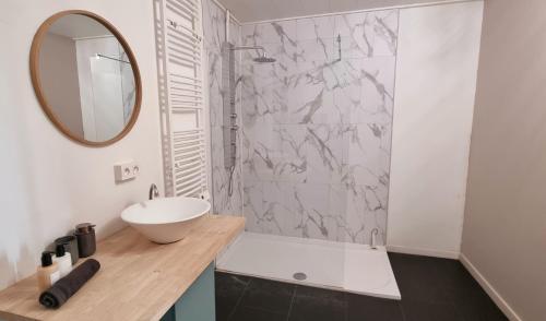 ein weißes Badezimmer mit einem Waschbecken und einem Spiegel in der Unterkunft Gite Haras du Bois de Formerie in Formerie