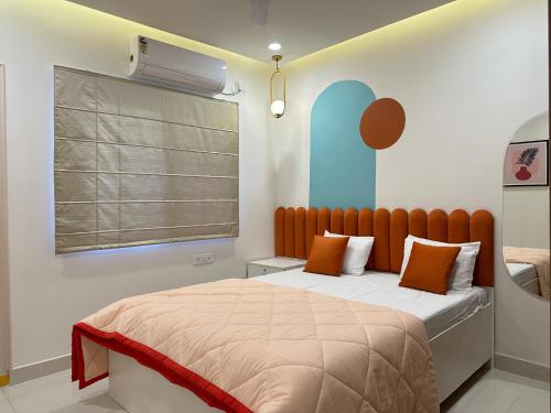 a bedroom with a bed and a window at Autumn suites in Hyderabad