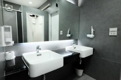 a bathroom with a white sink and a mirror at Wayha Hostel Don Mueang Airport in Bangkok