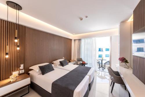 a hotel room with a large bed and a desk at Pavlo Napa Beach Hotel in Ayia Napa