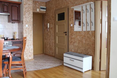 a kitchen with a table and a door and a table and chairs at Apartament BARTUŚ do 4 osób - STEGNA mierzeja wiślana in Stegna