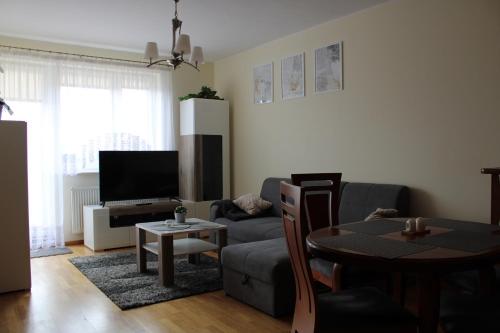 a living room with a couch and a table at Apartament BARTUŚ do 4 osób - STEGNA mierzeja wiślana in Stegna