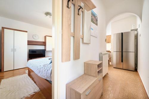 a bedroom with a bed and a kitchen with a refrigerator at App Forza in Umag