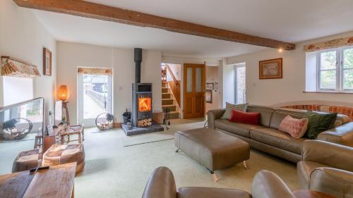 a living room with a couch and a fireplace at Wynyard Mill in Malmesbury