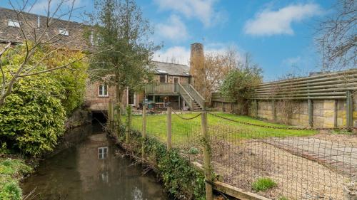 an old house with a canal in front of it at Wynyard Mill in Malmesbury