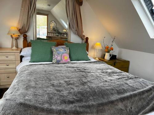 um quarto com uma cama grande e almofadas verdes em Quirky 1 bedroom barn on the river in Arundel em Arundel