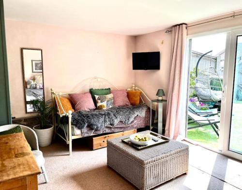 a living room with a couch with pillows on it at Quirky 1 bedroom barn on the river in Arundel in Arundel