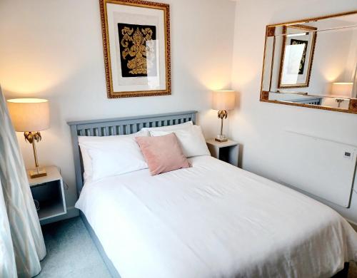 a bedroom with a white bed and two lamps at 'The Limes' - Air-Con Two Double Bedroom Holiday House with Private Garden in Kent